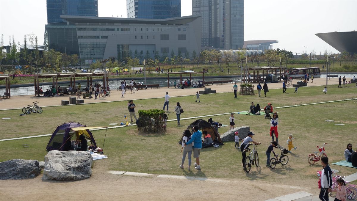 송도 센트럴파크 잔디밭에서 텐트를 치고 자전거를 타며 쉬는 시민들의 참고 사진